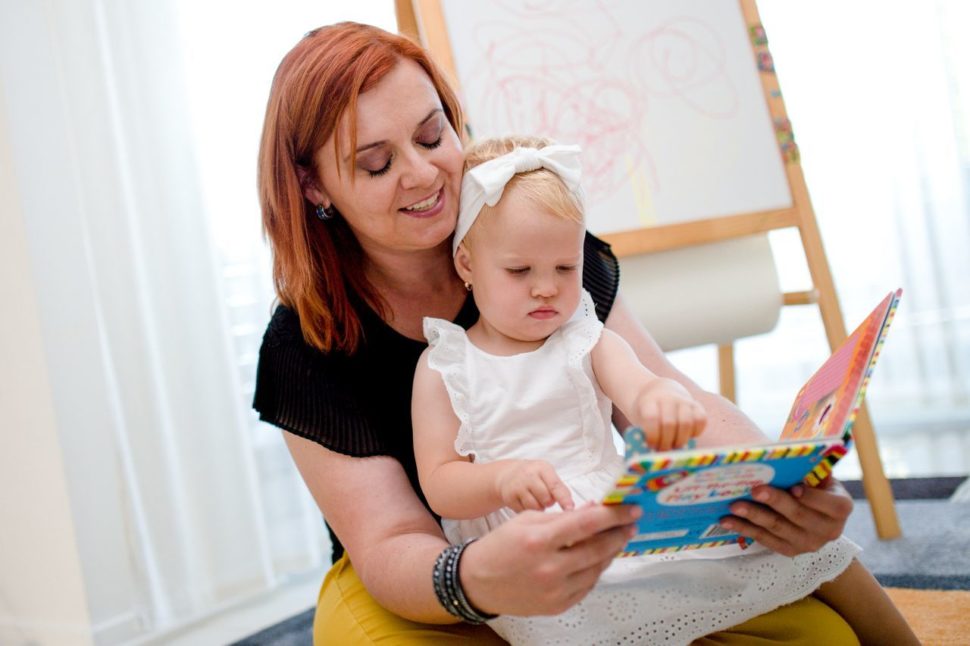 Silvia číta anglickú knižku dieťaťu, ktoré ukazuje na obrázok